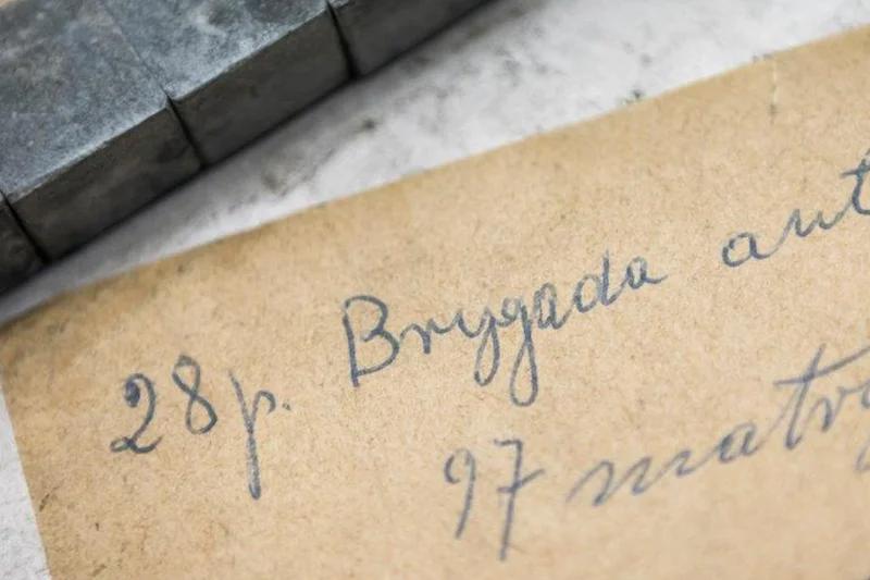 97 matrices of 28 point size Brygada typeface written on brown paper